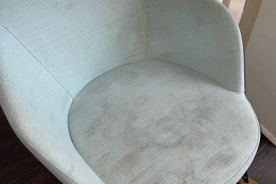 Stained fabric dining chair before professional cleaning in Silvassa